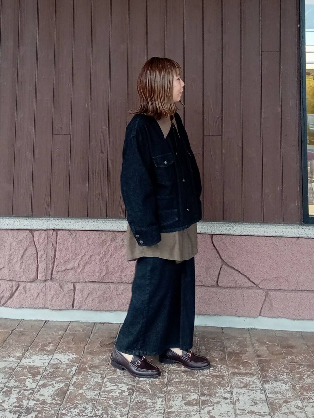 ブラウン系のローファー、ブラック系のスカート、ブラック系のデニムジャケットを着用したレディースの秋コーディネートの3枚目の写真