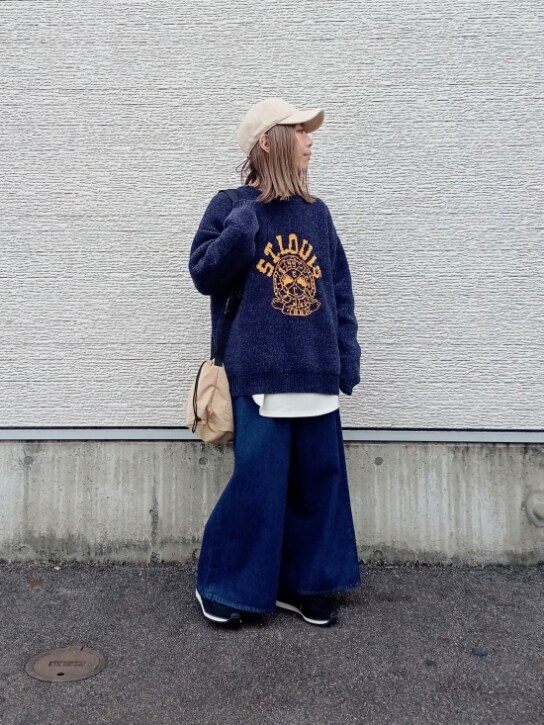 ブルー系のニット/セーター、ホワイト系のTシャツ/カットソー、ベージュ系のショルダーバッグを着用したレディースの秋コーディネートの2枚目の写真