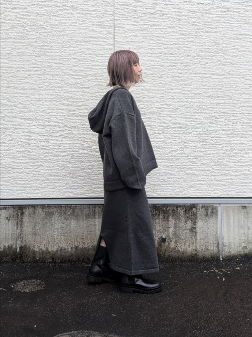 グレー系のニット/セーター、グレー系のスカート、ホワイト系のTシャツ/カットソーを着用したレディースの秋コーディネートの2枚目の写真