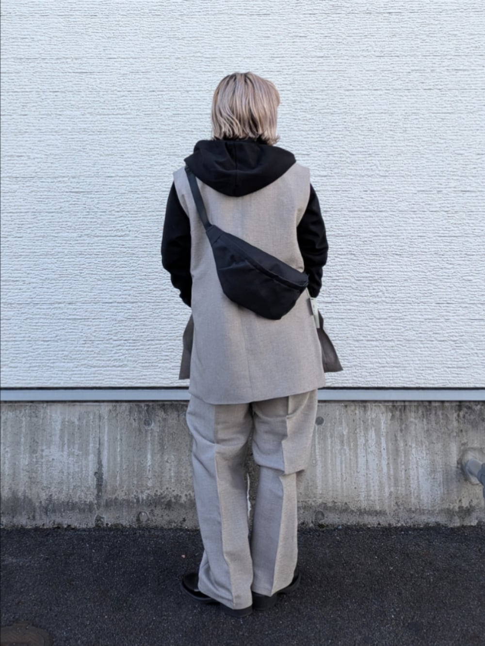 ベージュ系のセットアップ、ブラック系のパーカー、グレー系のTシャツ/カットソーを着用したレディースの冬コーディネートの3枚目の写真