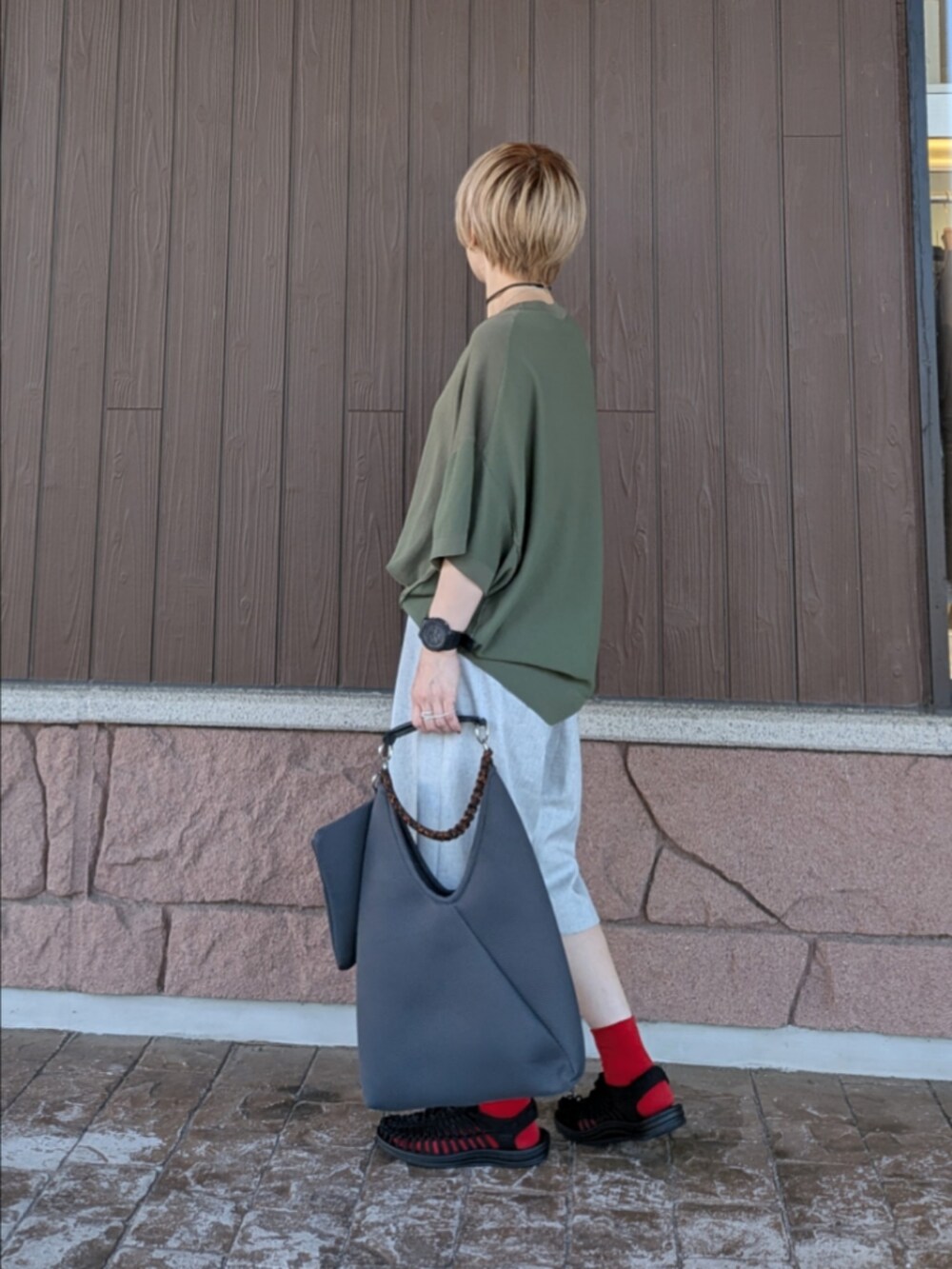 グリーン系のニット/セーター、グレー系のその他パンツ、ブラック系のサンダルを着用したレディースの夏コーディネートの4枚目の写真