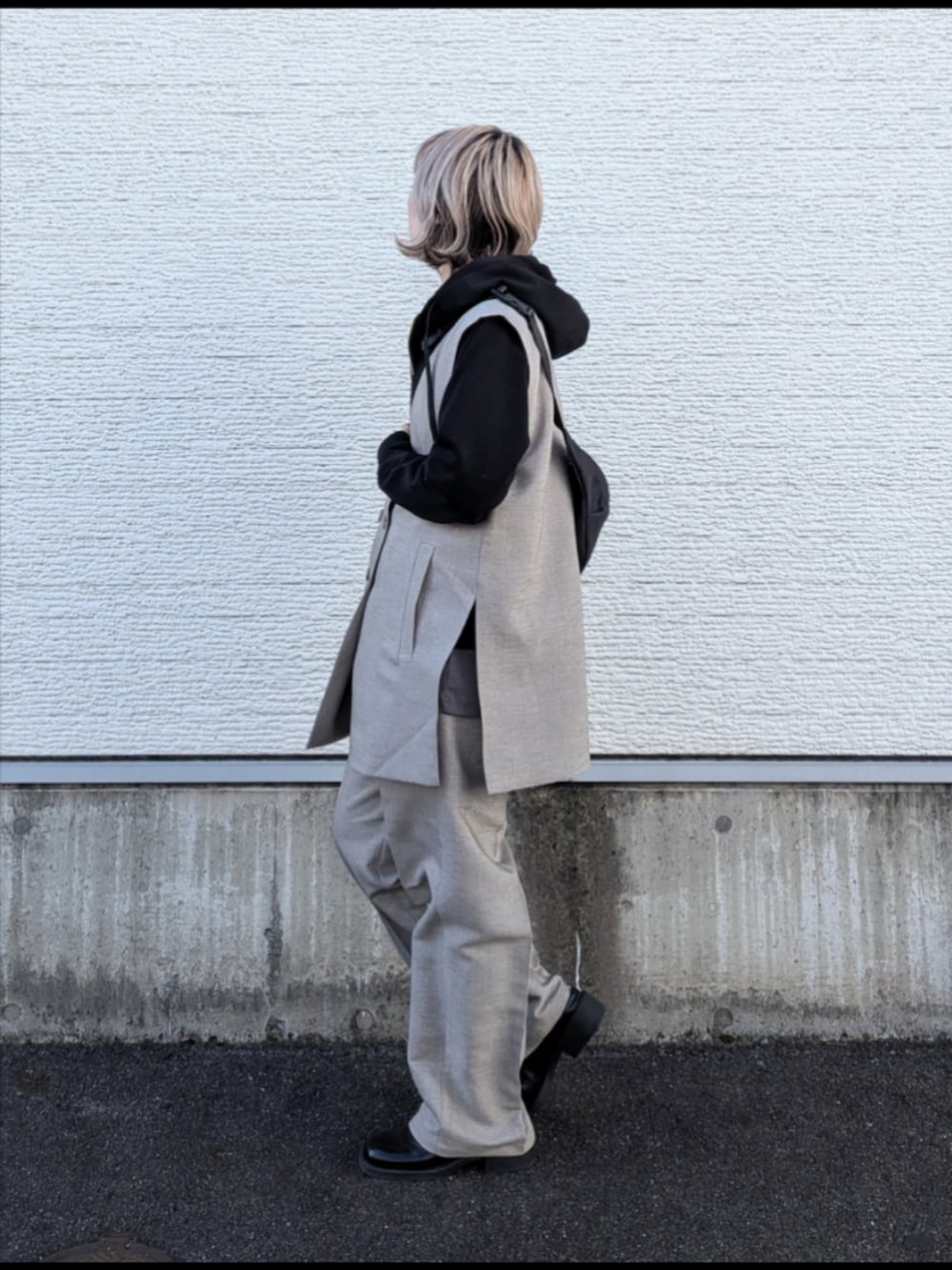 ベージュ系のセットアップ、ブラック系のパーカー、グレー系のTシャツ/カットソーを着用したレディースの冬コーディネートの2枚目の写真