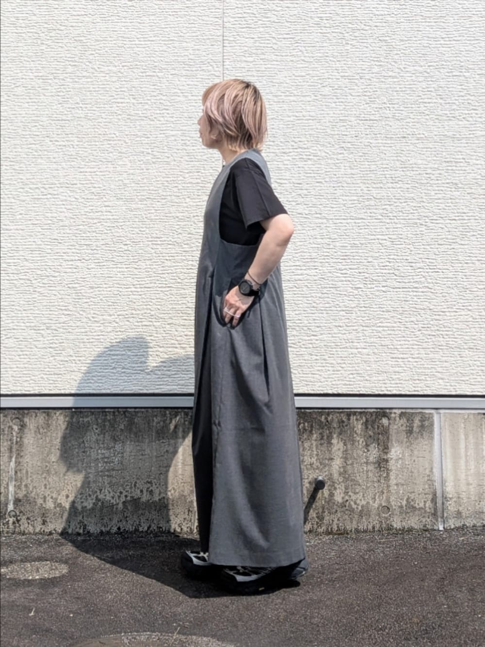 グレー系のワンピース、ブラック系のTシャツ/カットソー、ブラック系のスニーカーを着用したレディースの夏コーディネートの2枚目の写真