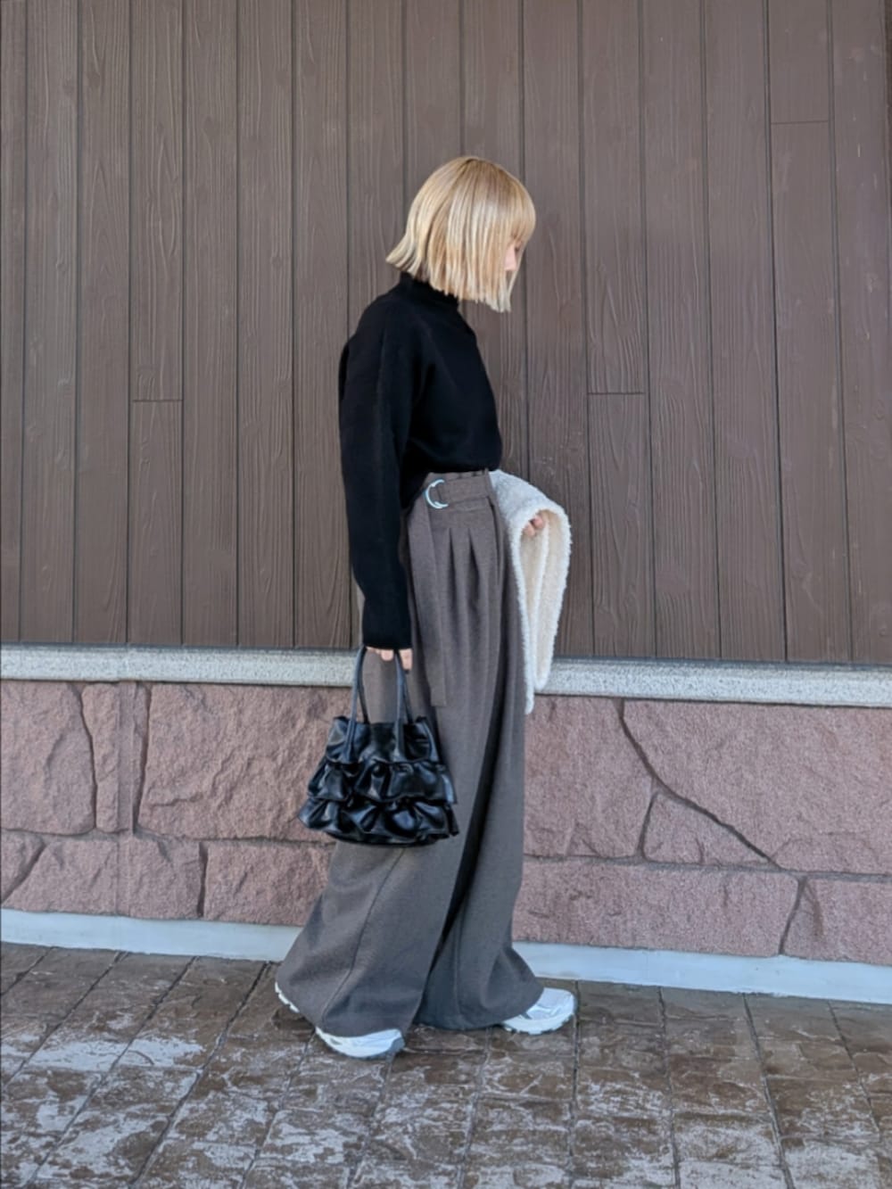 ブラック系のニット/セーター、ブラック系のその他パンツ、ブラック系のハンドバッグを着用したレディースの冬コーディネートの2枚目の写真