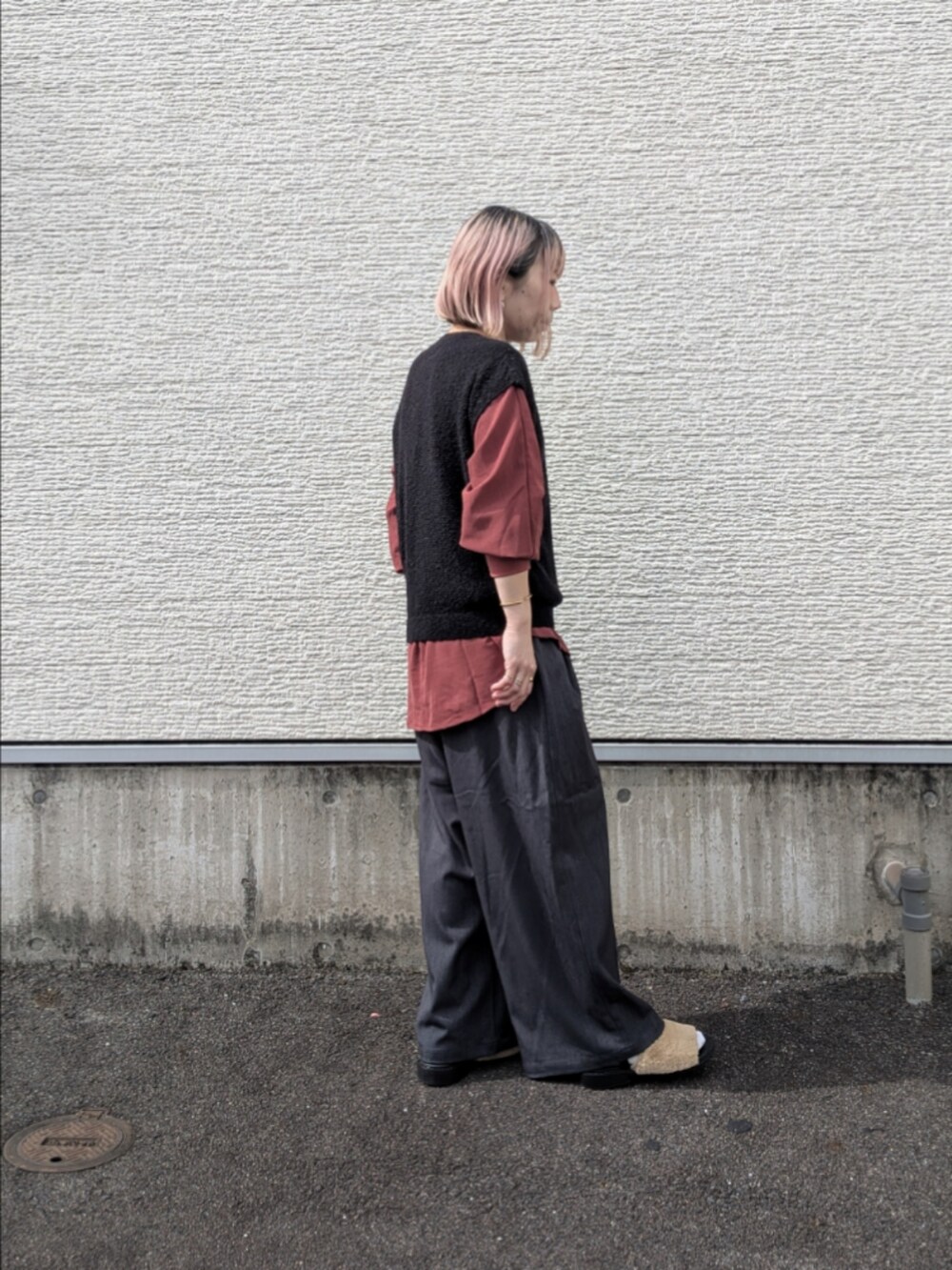 レッド系のシャツ/ブラウス、ブラック系のベスト、グレー系のその他パンツを着用したレディースの秋コーディネートの4枚目の写真