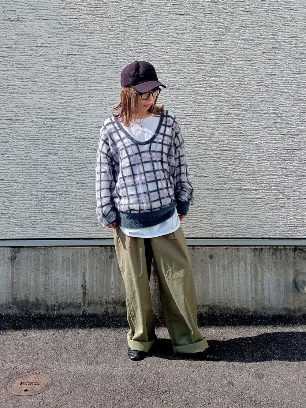 グレー系のニット/セーター、グリーン系のチノパンツ、ブラック系のメガネを着用したレディースの秋コーディネートの6枚目の写真