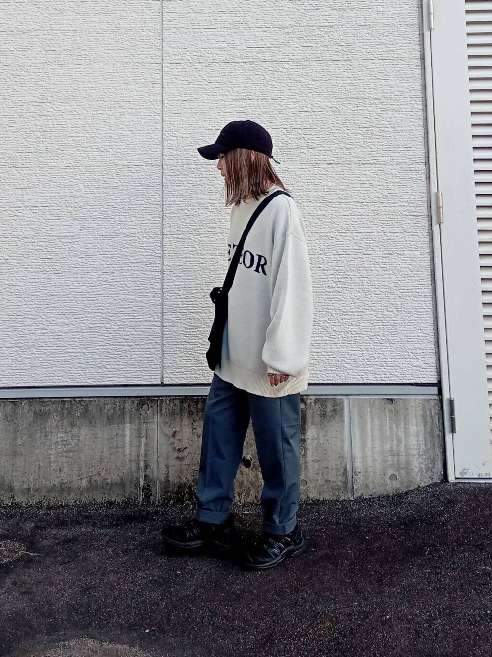 ブラック系のショルダーバッグ、ホワイト系のニット/セーター、グレー系のその他パンツを着用したレディースの秋コーディネートの2枚目の写真