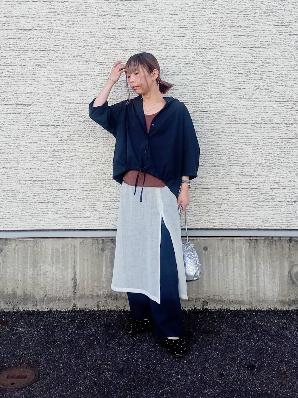 ホワイト系のスカート、ブラック系のパンプス、シルバー系のショルダーバッグを着用したレディースの春コーディネートの5枚目の写真