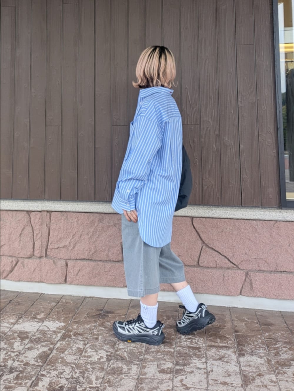 ブルー系のシャツ/ブラウス、グレー系のその他パンツ、ブラック系のスニーカーを着用したレディースの春コーディネートの2枚目の写真