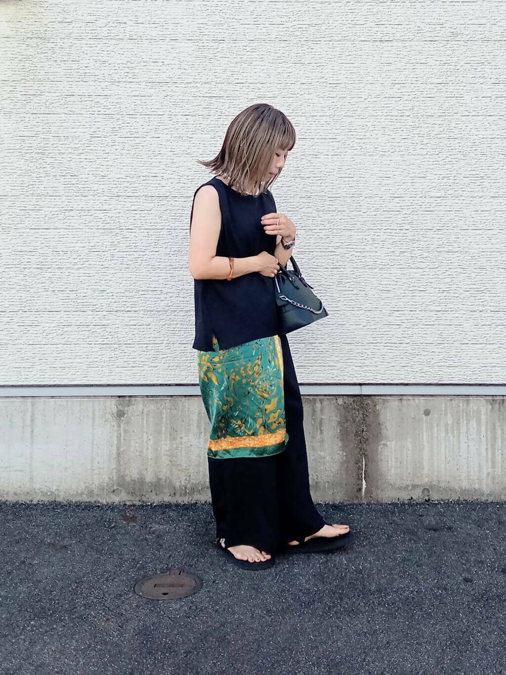 ブラック系のサロペット/オーバーオール、ブラック系のボストンバッグ、ブラック系のサンダルを着用したレディースの夏コーディネートの3枚目の写真