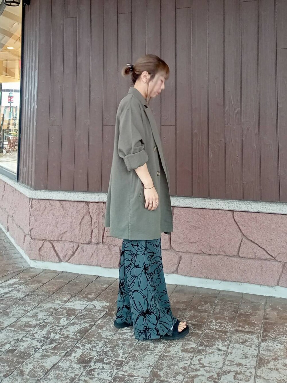 グリーン系のテーラードジャケット、ブラック系のニット/セーター、ブラウン系のその他パンツを着用したレディースの夏コーディネートの2枚目の写真