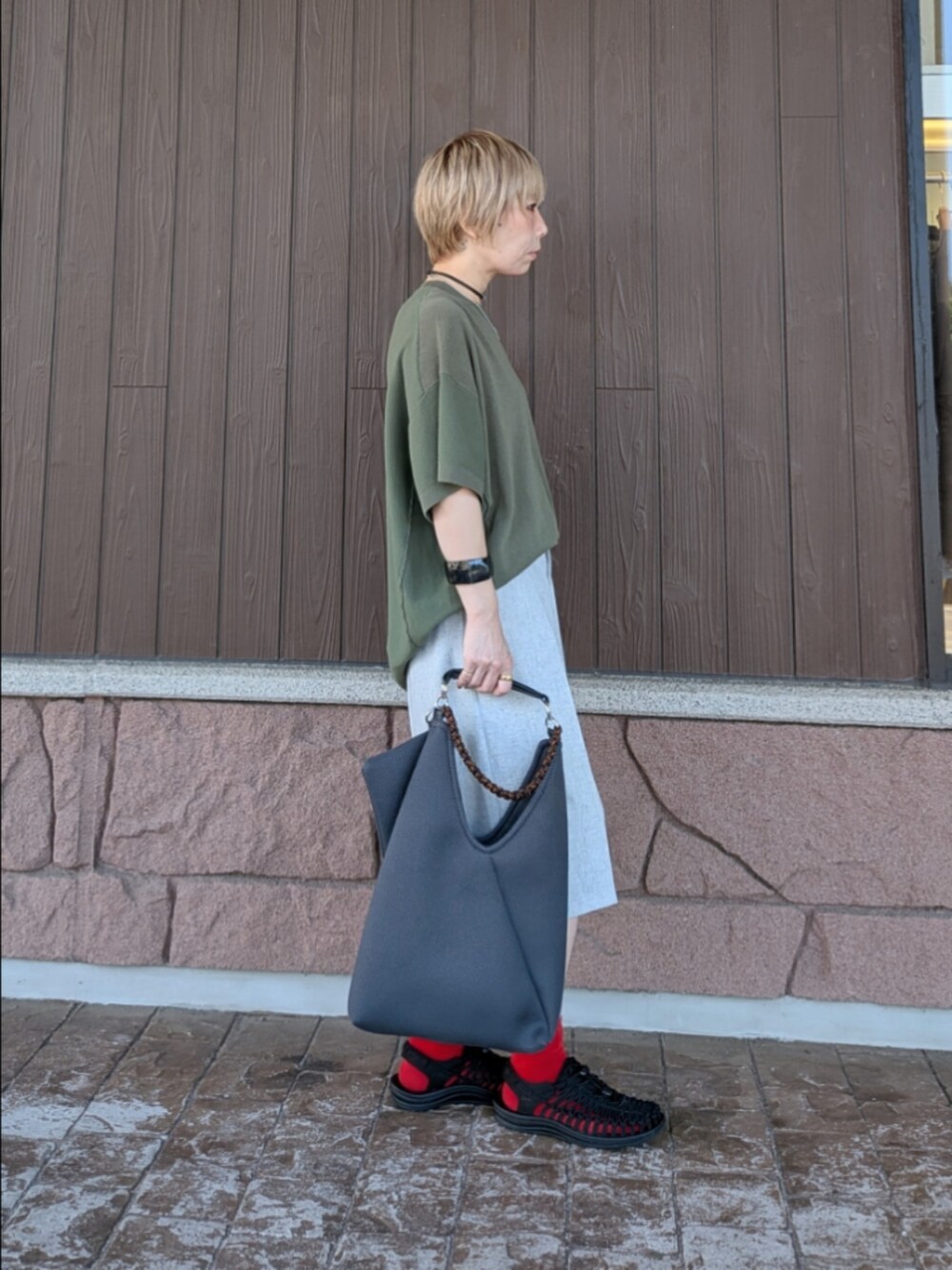 グリーン系のニット/セーター、グレー系のその他パンツ、ブラック系のサンダルを着用したレディースの夏コーディネートの3枚目の写真