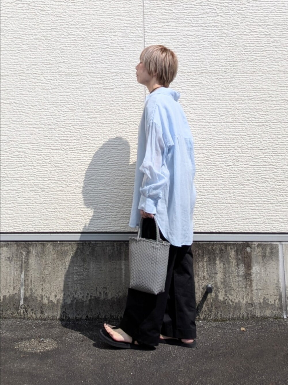 ブルー系のシャツ/ブラウス、ブラック系のTシャツ/カットソー、グレー系のトートバッグを着用したレディースの夏コーディネートの2枚目の写真