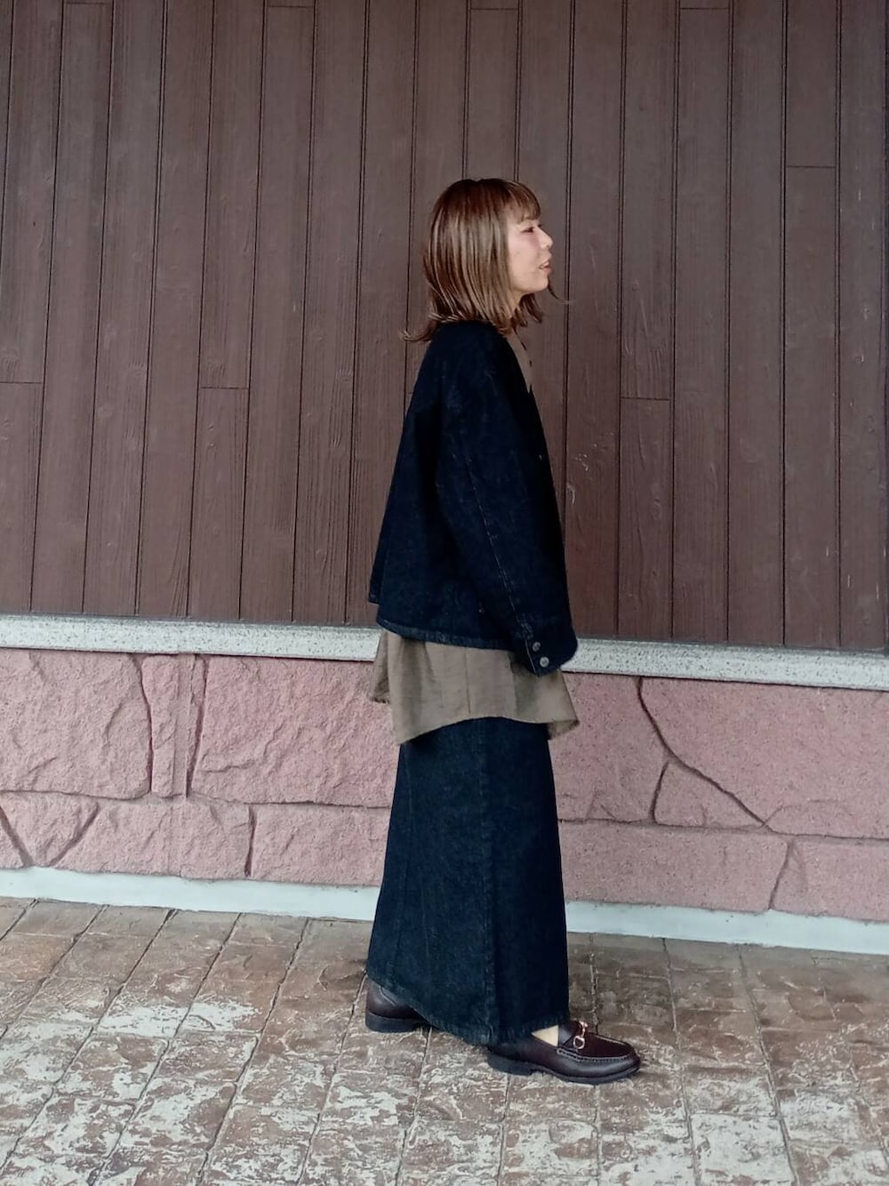 ブラウン系のローファー、ブラック系のスカート、ブラック系のデニムジャケットを着用したレディースの秋コーディネートの5枚目の写真