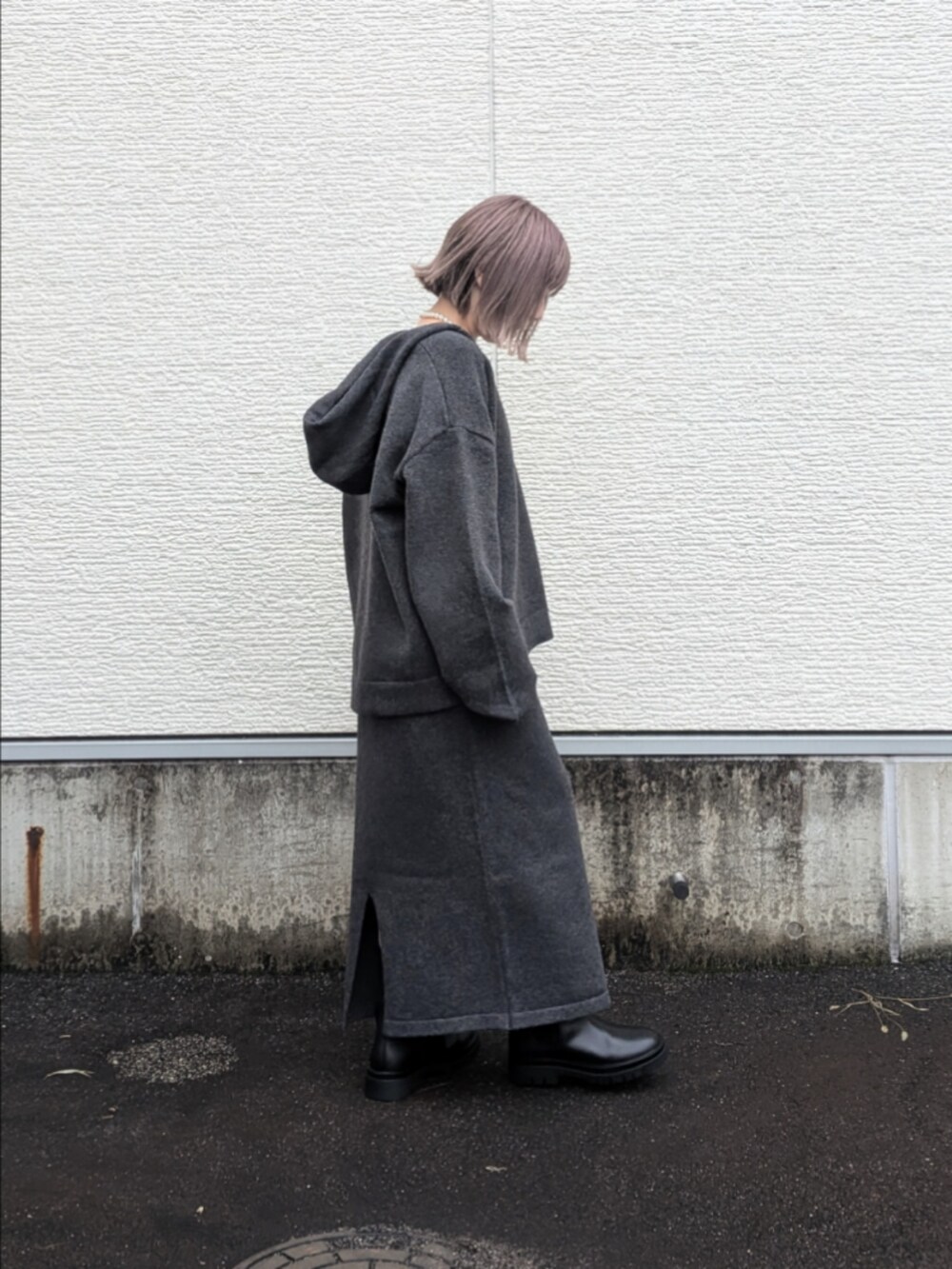 グレー系のニット/セーター、グレー系のスカート、ホワイト系のTシャツ/カットソーを着用したレディースの秋コーディネートの3枚目の写真