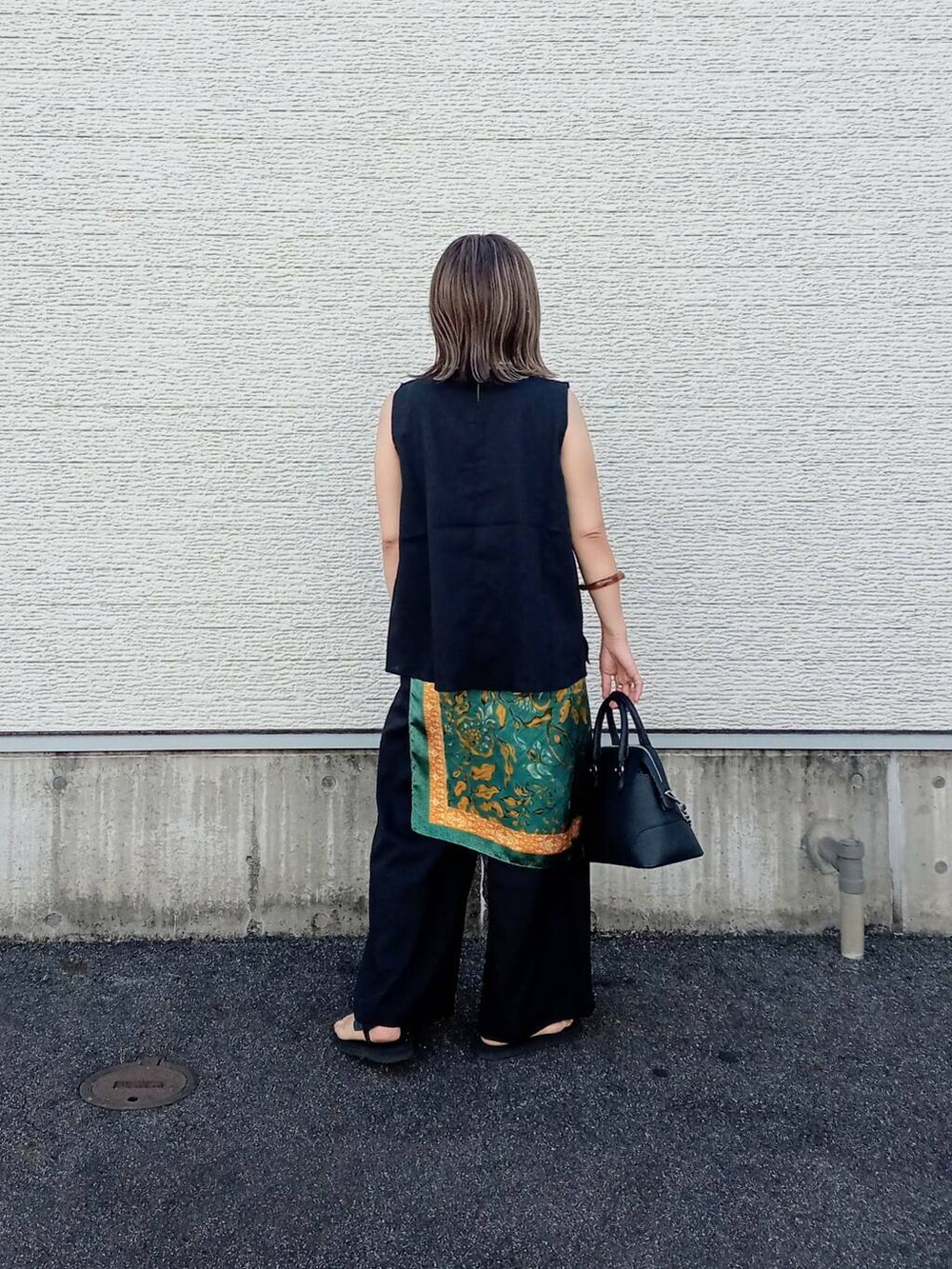 ブラック系のサロペット/オーバーオール、ブラック系のボストンバッグ、ブラック系のサンダルを着用したレディースの夏コーディネートの4枚目の写真