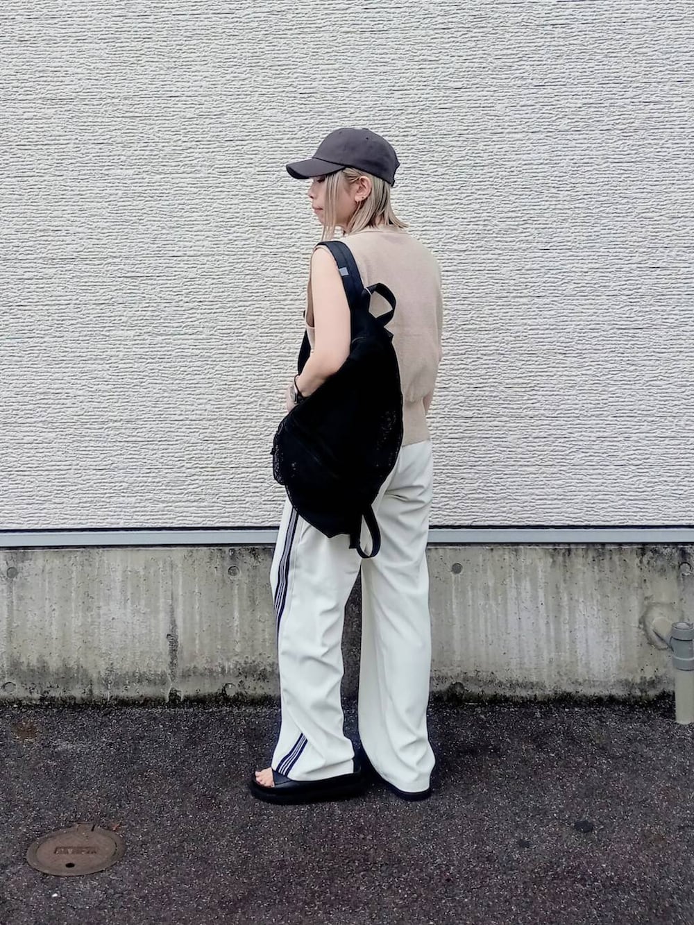 ブラック系のバックパック/リュック、ホワイト系のその他パンツ、ベージュ系のベストを着用したレディースの夏コーディネートの3枚目の写真