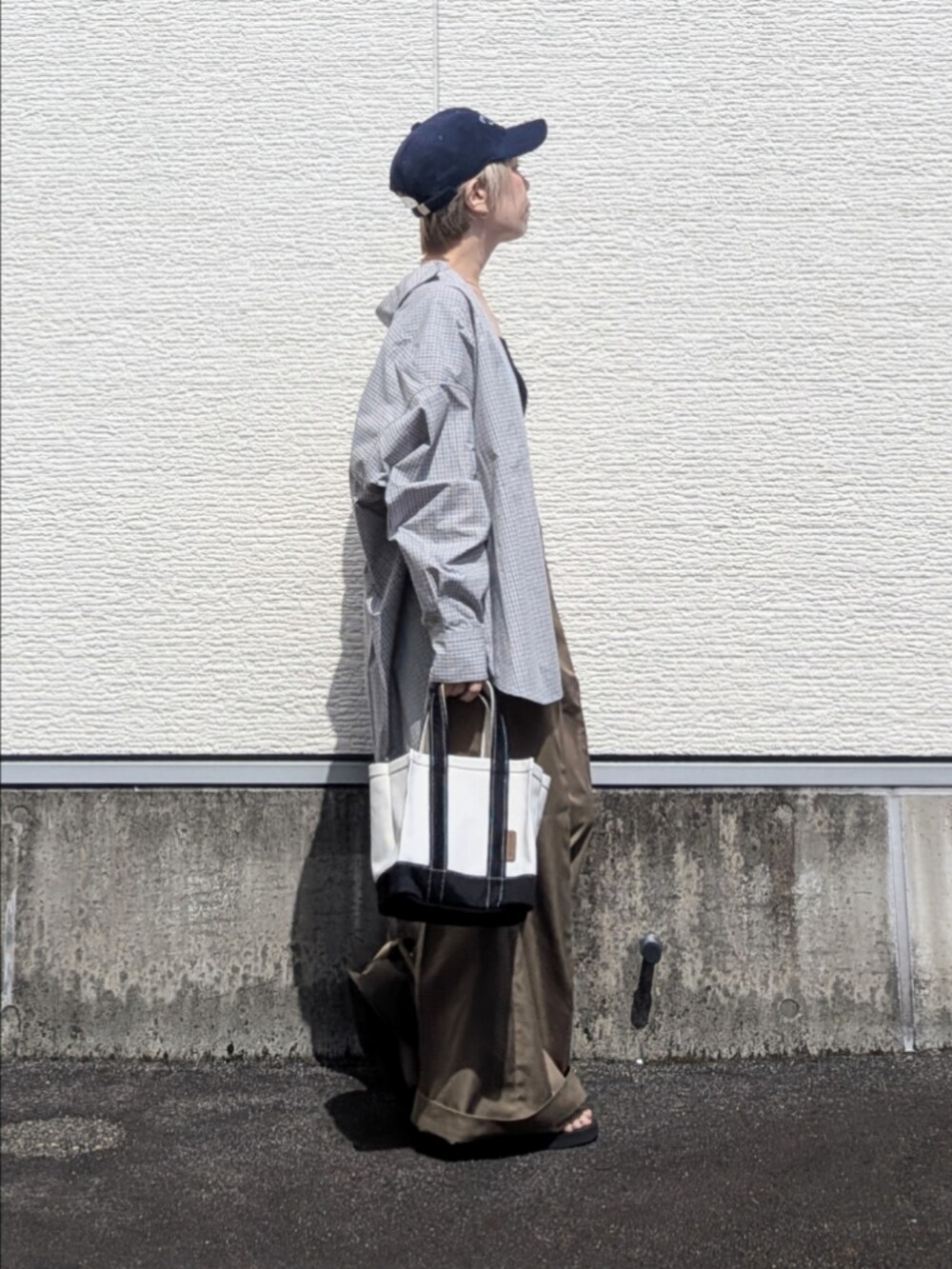ブルー系のシャツ/ブラウス、ベージュ系のチノパンツ、ブラック系のトートバッグを着用したレディースの秋コーディネートの4枚目の写真