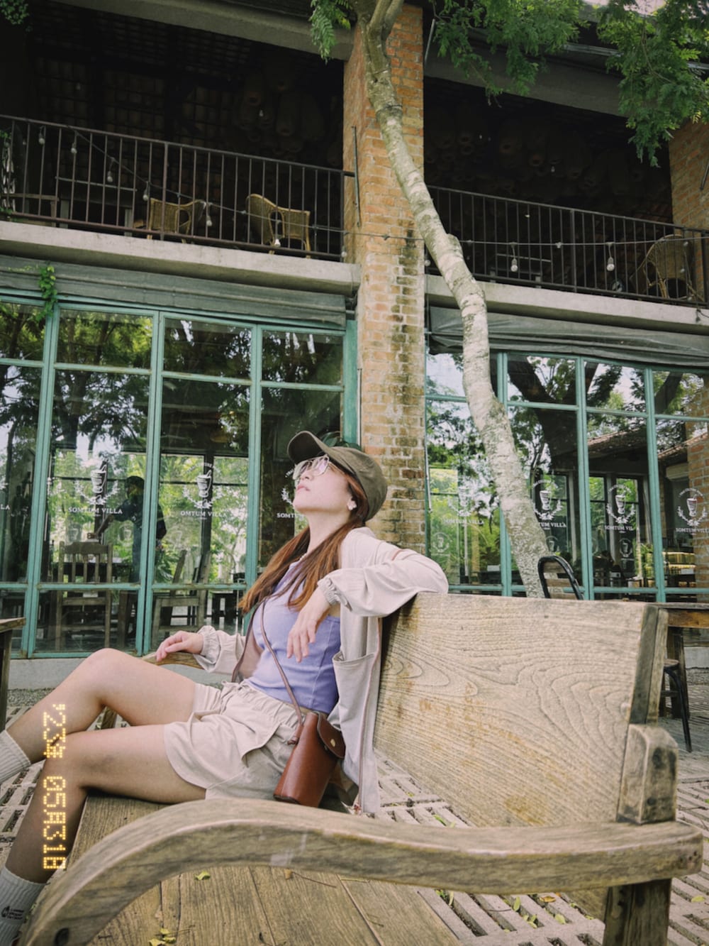 パープル系のタンクトップ、ブラウン系のショルダーバッグ、ベージュ系のカーゴパンツを着用したレディースの夏コーディネートの2枚目の写真