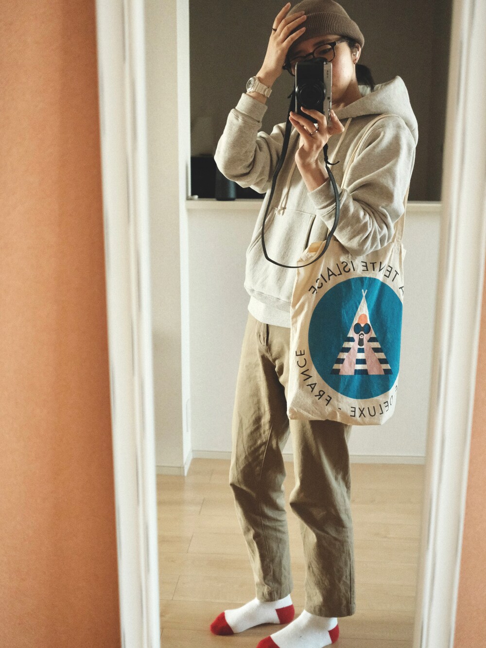 ベージュ系のチノパンツ、グレー系のパーカーを着用したレディースの春コーディネートの2枚目の写真