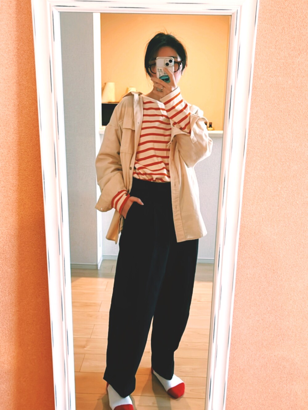 オレンジ系のトップス、ブラック系のその他パンツ、ホワイト系のトップスを着用したレディースの春コーディネートの2枚目の写真