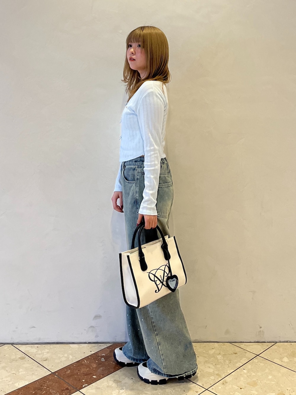 ブルー系のその他パンツ、ブラック系のスニーカー、ホワイト系のトートバッグを着用したレディースの冬コーディネートの5枚目の写真