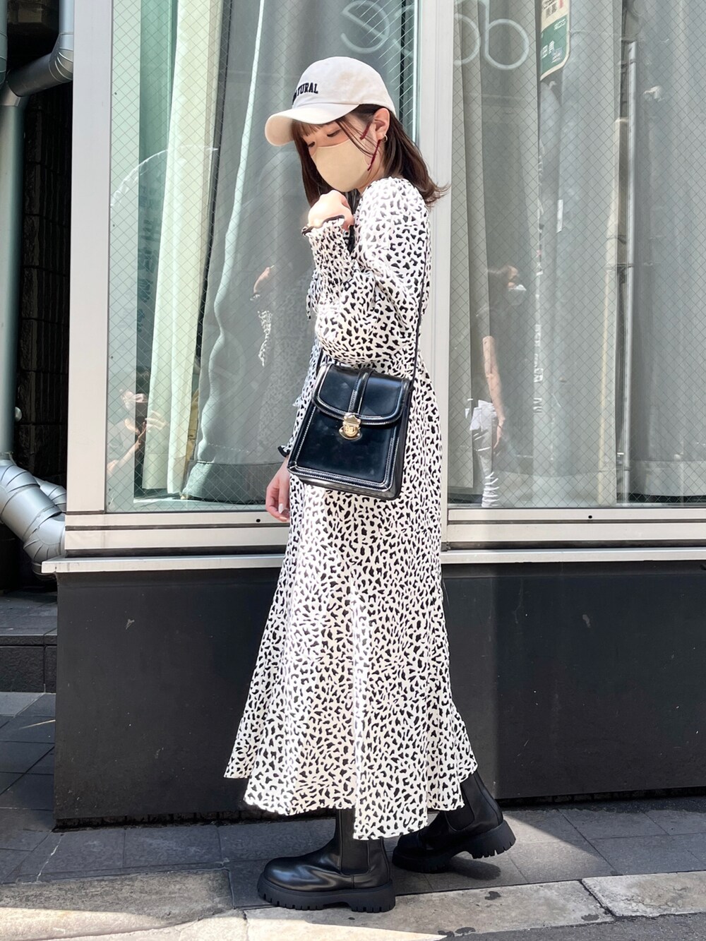 ホワイト系のワンピース、ブラック系のブーツ、ブラック系のショルダーバッグを着用したレディースの夏コーディネートの4枚目の写真