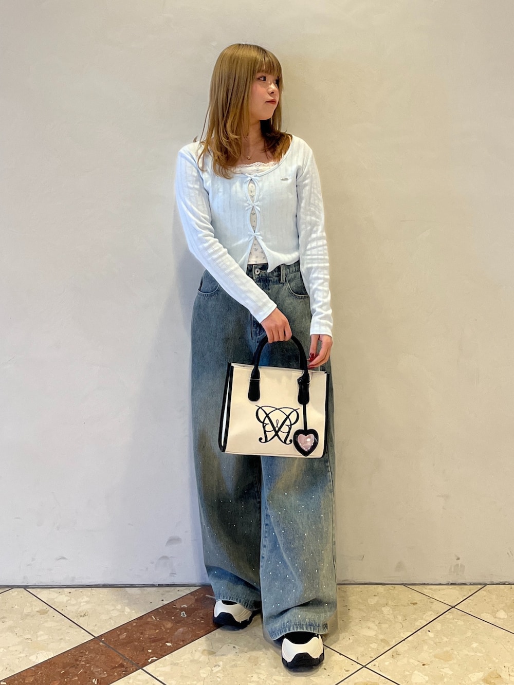 ブルー系のその他パンツ、ブラック系のスニーカー、ホワイト系のトートバッグを着用したレディースの冬コーディネートの4枚目の写真