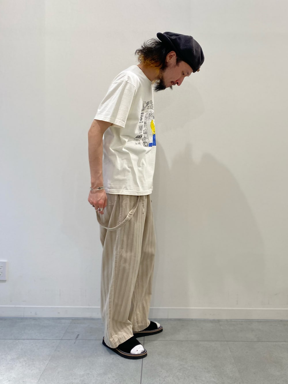 ホワイト系のTシャツ/カットソー、ベージュ系のサロペット/オーバーオール、ブラック系のサンダルを着用したメンズの春コーディネートの2枚目の写真