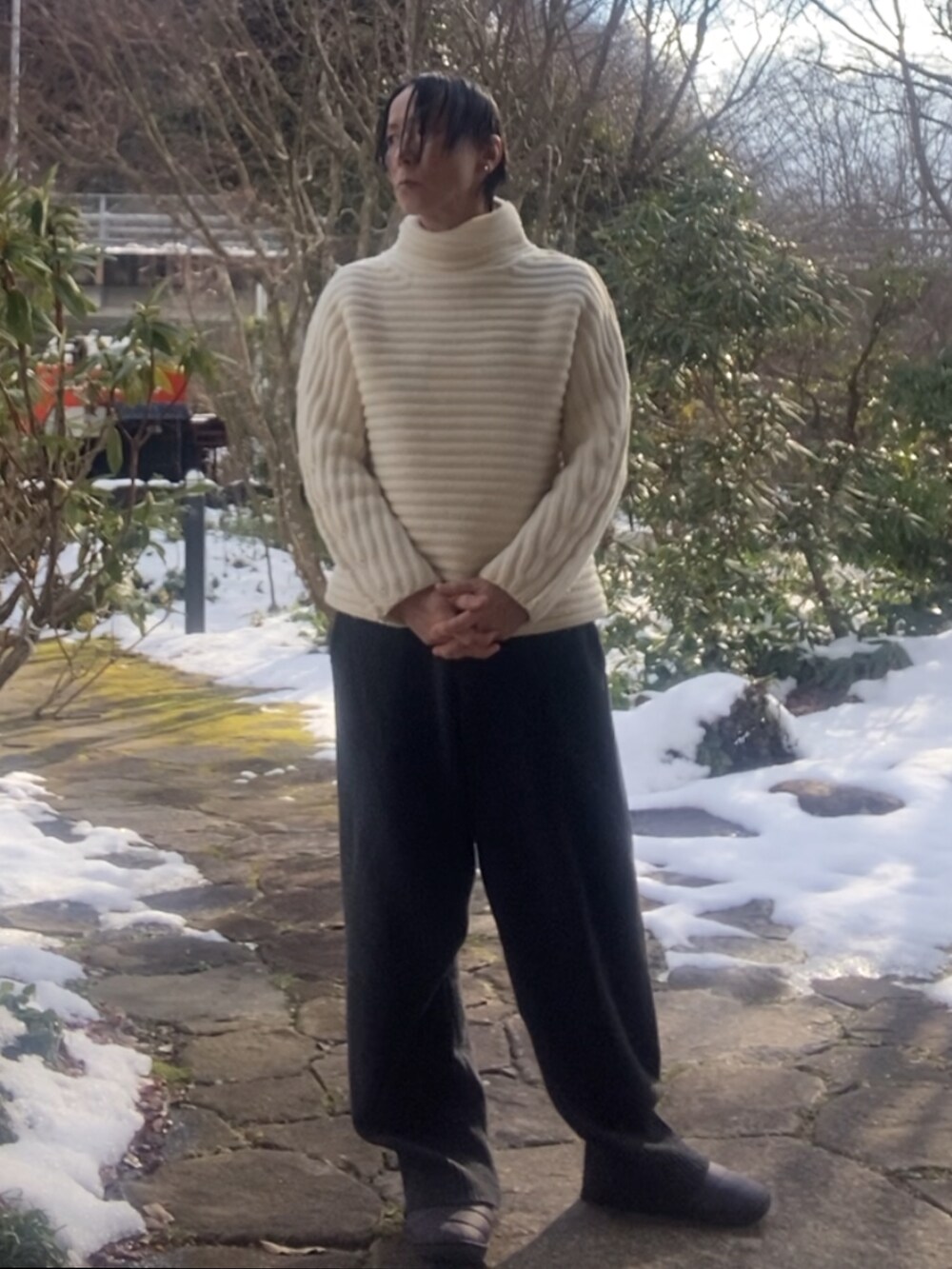 ホワイト系のニット/セーター、グレー系のその他パンツ、グレー系のサンダルを着用したメンズの冬コーディネートの2枚目の写真