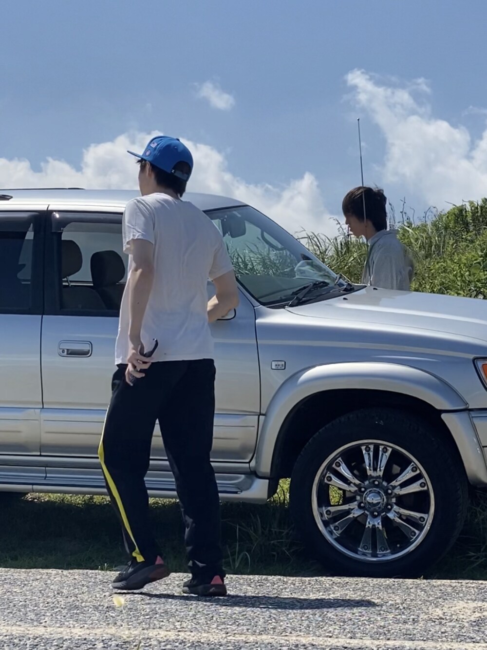 ベージュ系のTシャツ/カットソー、ブラック系のパンツ、ブラック系のスニーカーを着用したメンズの夏コーディネートの3枚目の写真