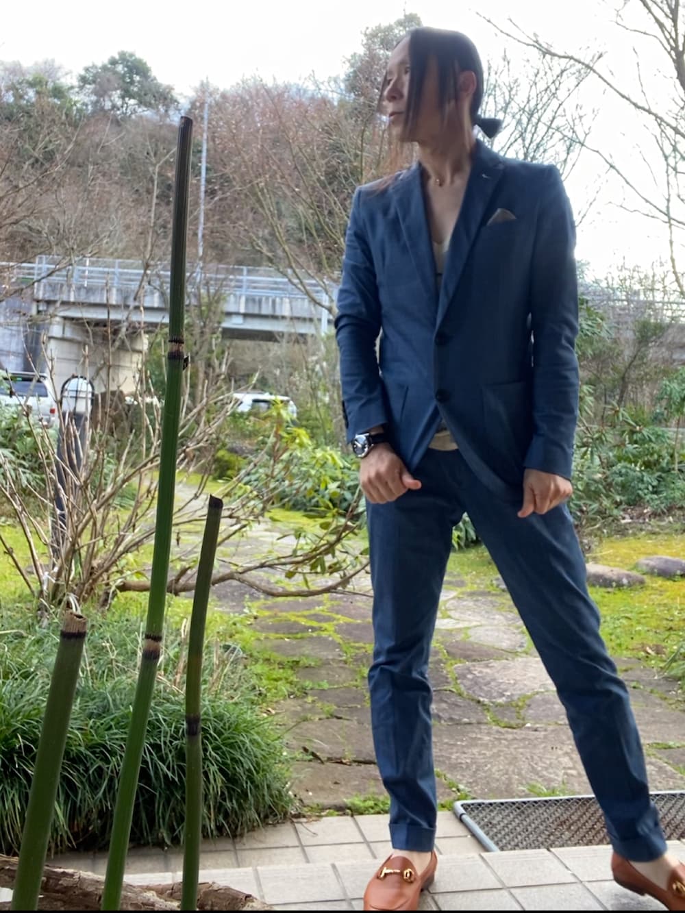 ブルー系のセットアップ、ブラウン系のスリッポン、ブラック系の腕時計を着用したメンズの冬コーディネートの2枚目の写真