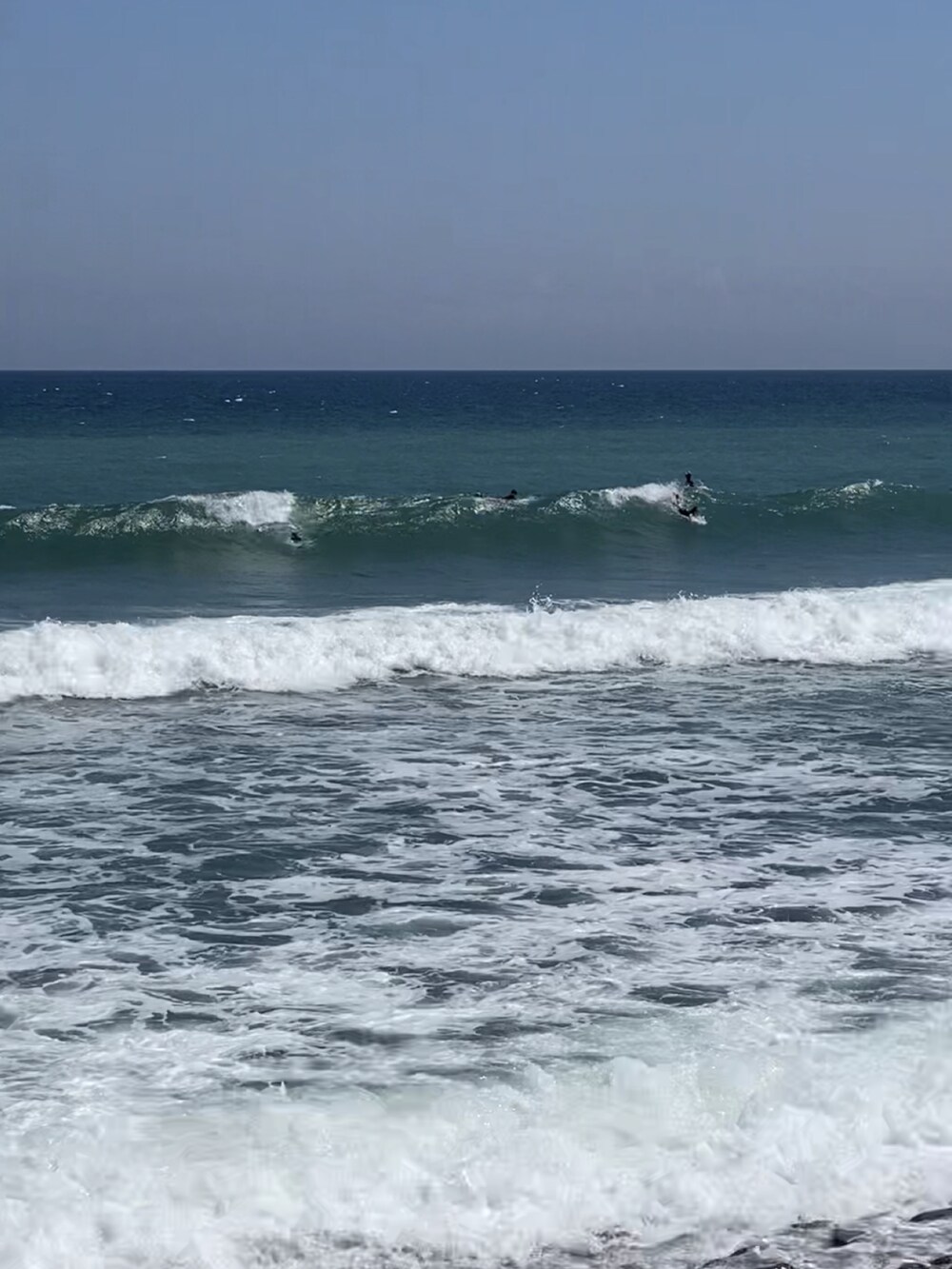 ベージュ系のTシャツ/カットソー、ブラック系のパンツ、ブラック系のスニーカーを着用したメンズの夏コーディネートの4枚目の写真