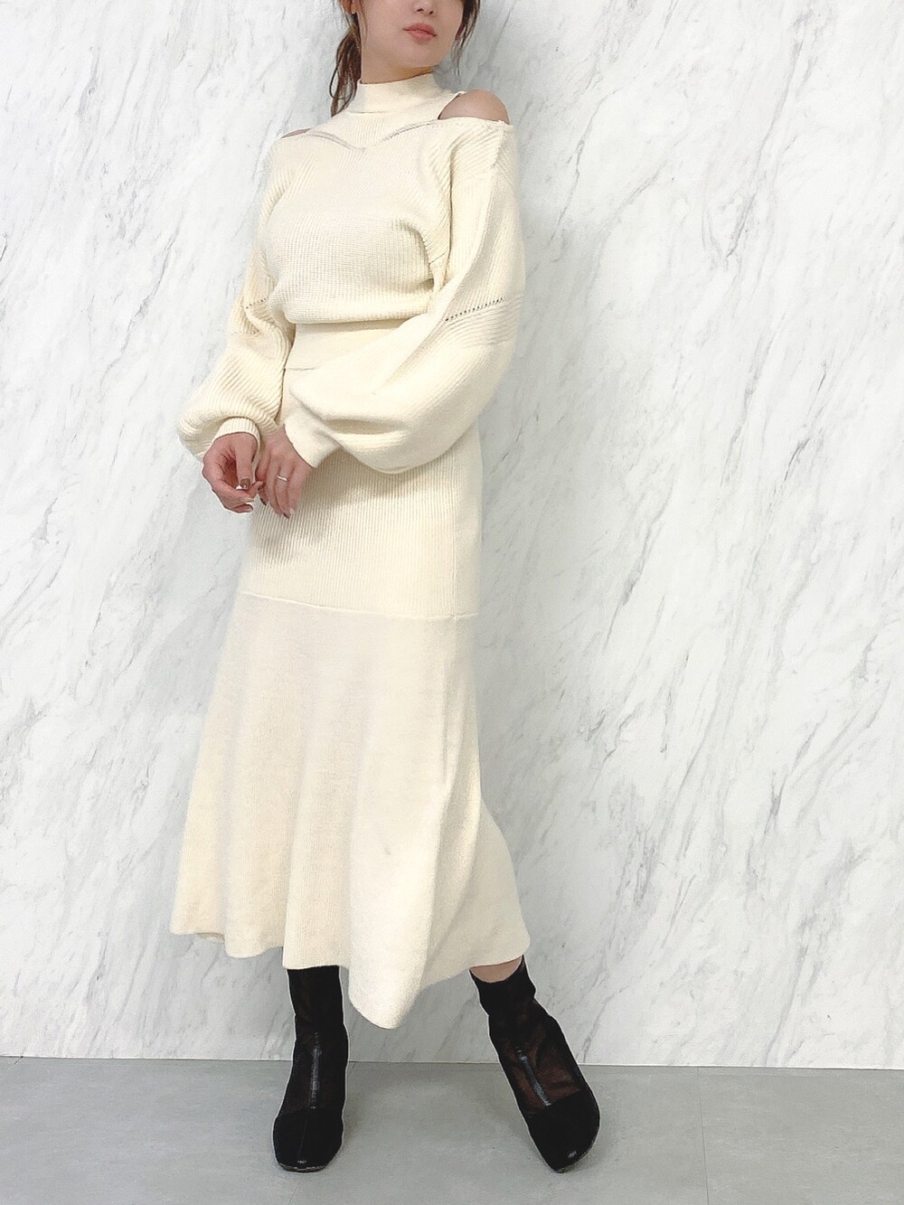 ホワイト系のワンピース、ブラック系のブーツを着用したレディースの冬コーディネートの2枚目の写真