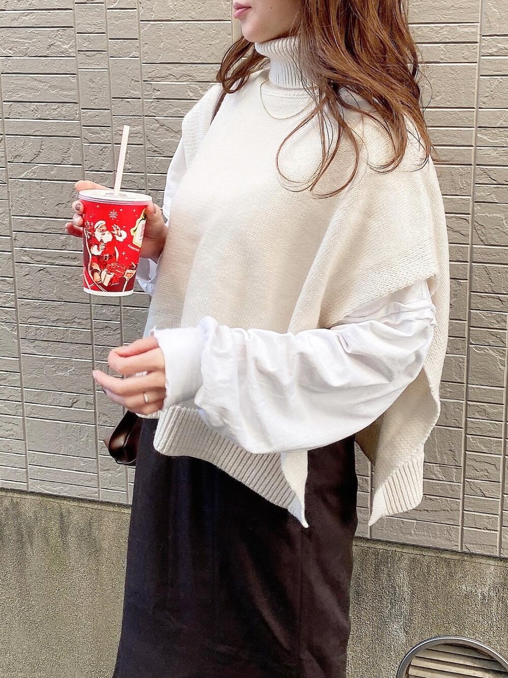 ブラウン系のスカート、ホワイト系のTシャツ/カットソー、ホワイト系のブーツを着用したレディースの冬コーディネートの3枚目の写真