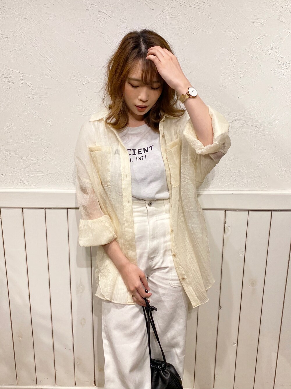 ホワイト系のデニムパンツ、ブラック系のサンダル、ホワイト系のTシャツ/カットソーを着用したレディースの春コーディネートの2枚目の写真