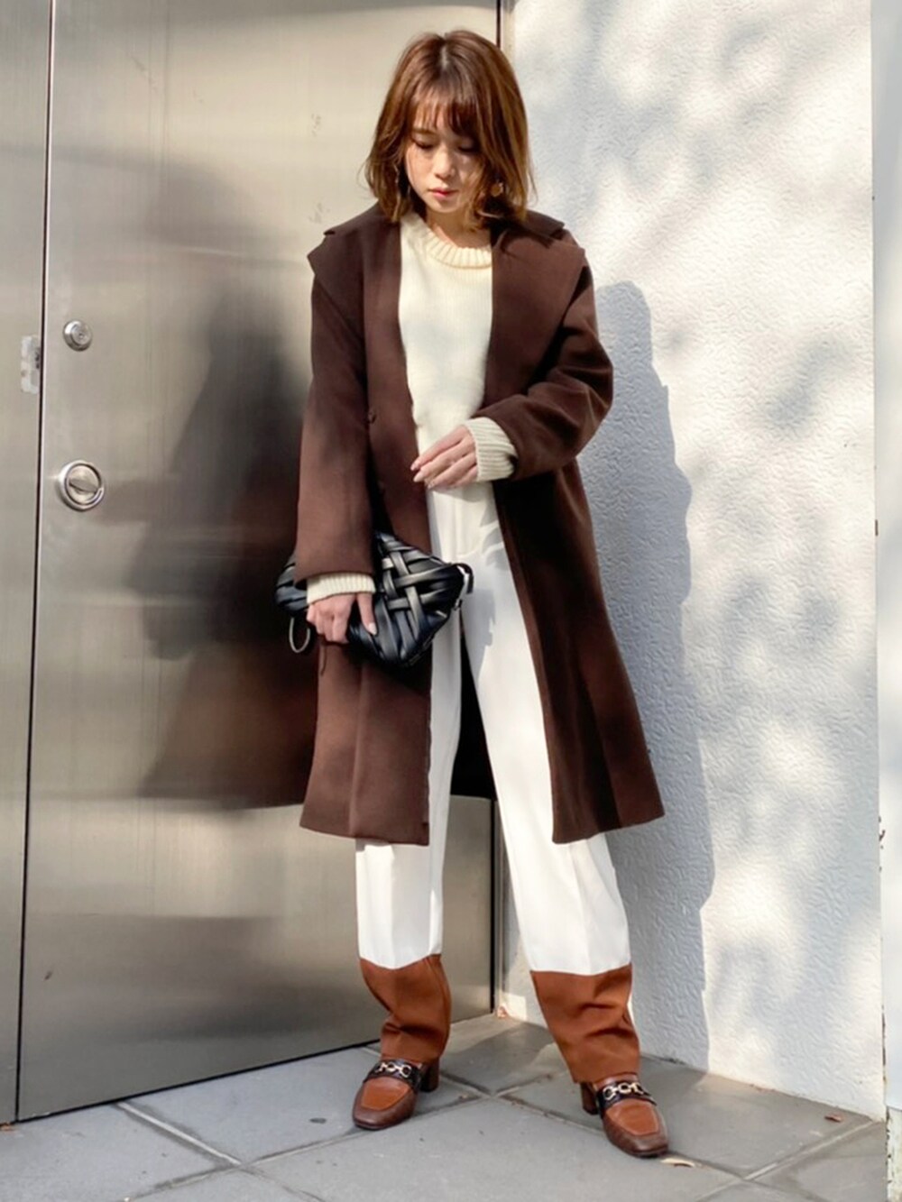 ホワイト系のその他パンツ、ブラウン系のローファー、ブラック系のクラッチバッグを着用したレディースの秋コーディネートの2枚目の写真
