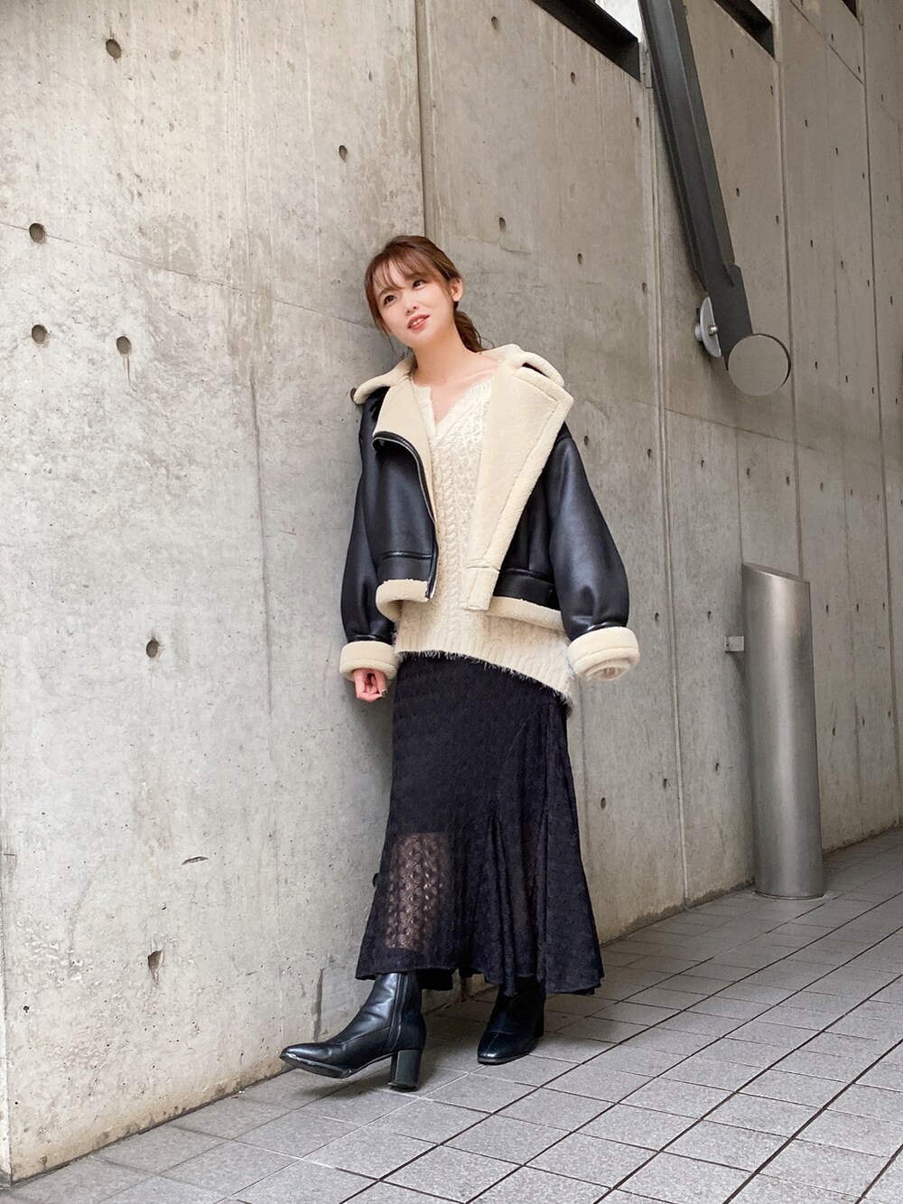 ブラック系のブルゾン、ブラック系のスカート、ベージュ系のニット/セーターを着用したレディースの秋コーディネートの2枚目の写真