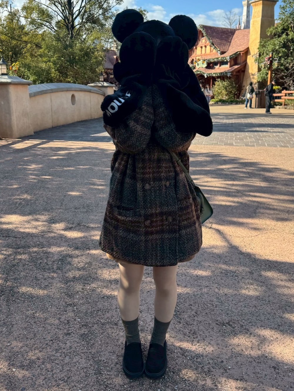 ブラック系のローファー、ブラウン系のテーラードジャケット、グリーン系のバッグを着用したレディースの冬コーディネートの2枚目の写真