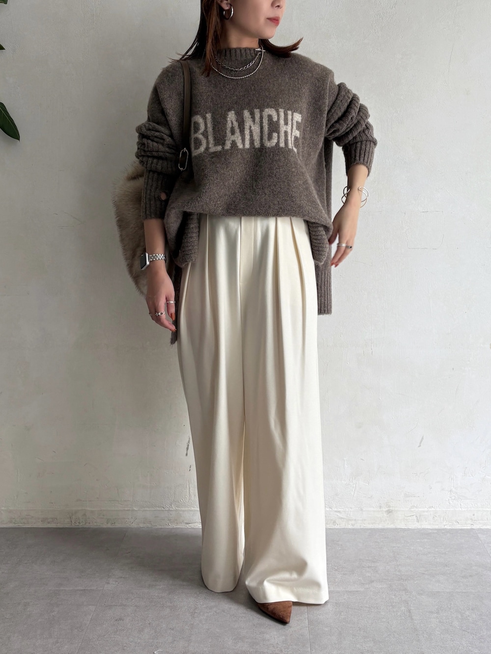 ベージュ系のニット/セーター、ホワイト系のその他パンツを着用したレディースの秋コーディネートの2枚目の写真