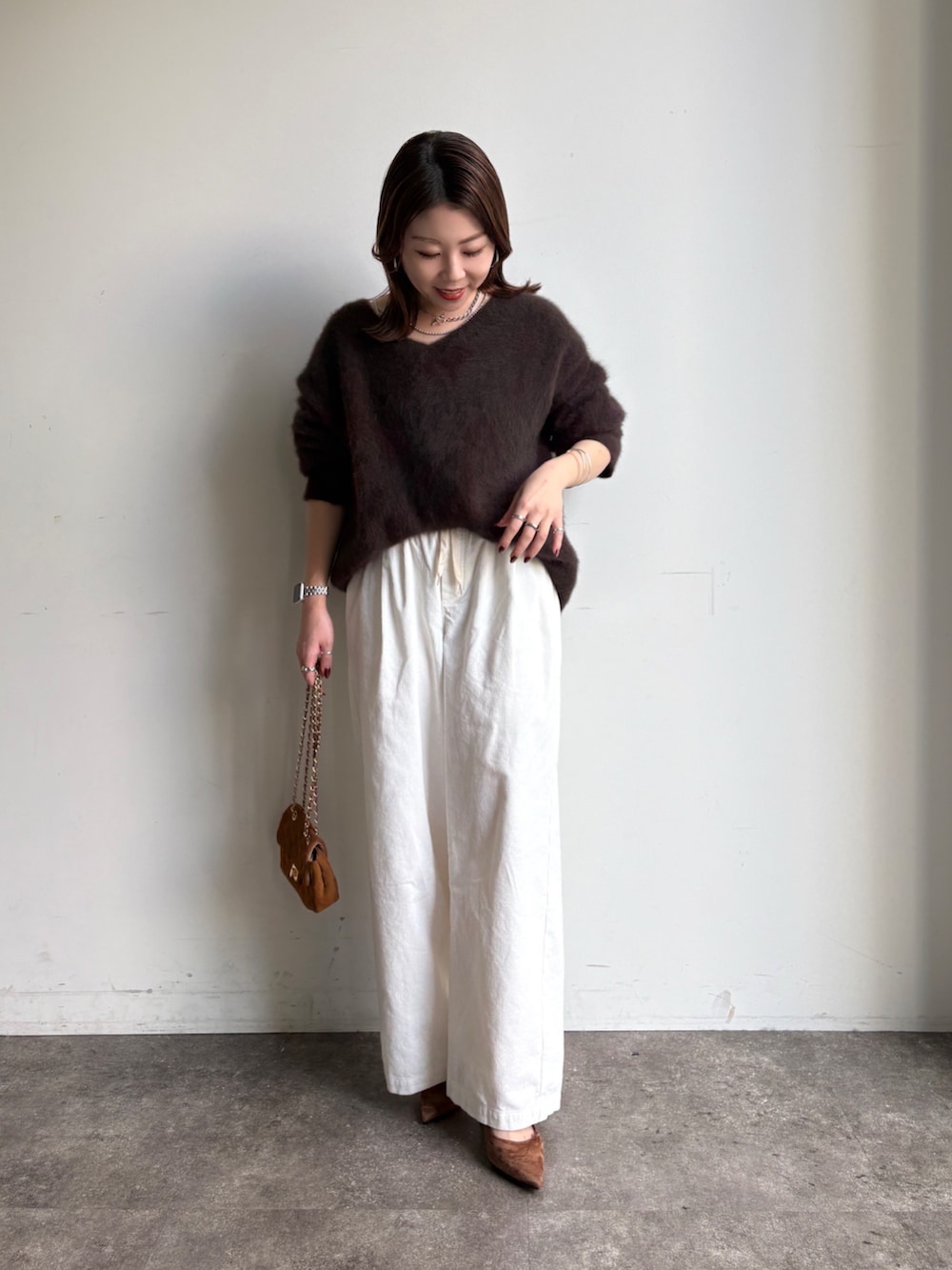 ブラウン系のニット/セーター、イエロー系のショルダーバッグ、ホワイト系のその他パンツを着用したレディースの冬コーディネートの2枚目の写真