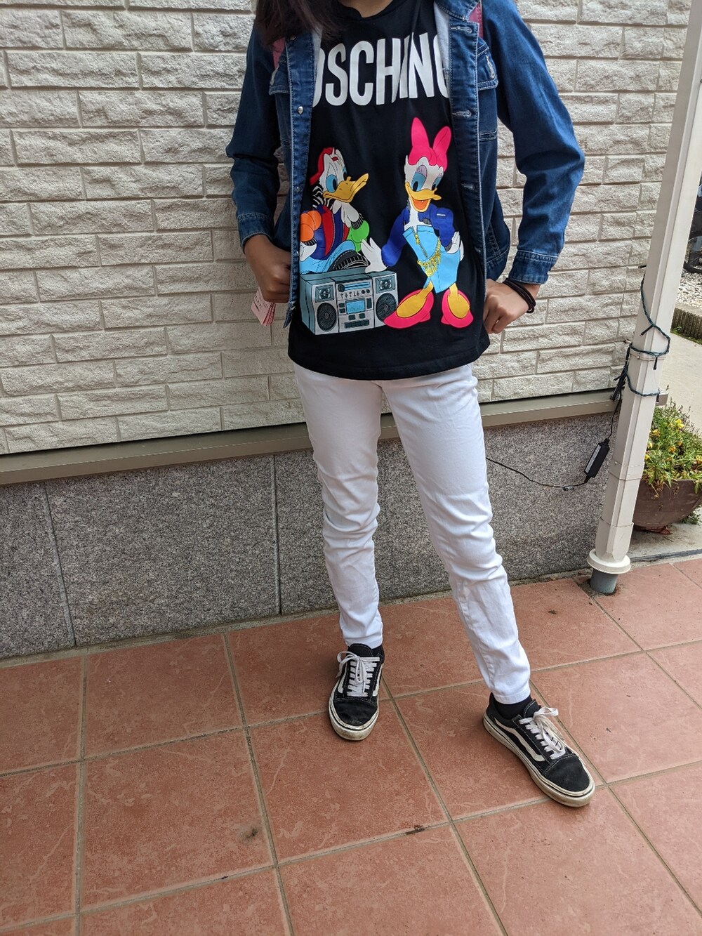 ホワイト系のデニムパンツ、ブラック系のTシャツ/カットソー、ブラック系のスニーカーを着用したレディースの夏コーディネートの2枚目の写真