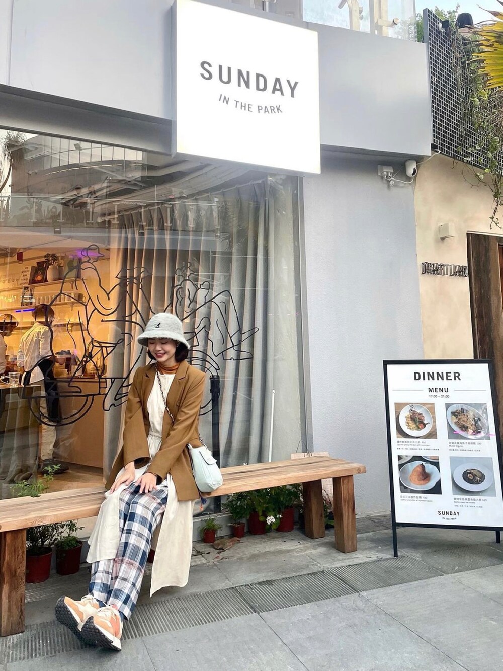 ベージュ系のベスト、ブルー系のショルダーバッグ、オレンジ系のスニーカーを着用したレディースの春コーディネートの3枚目の写真