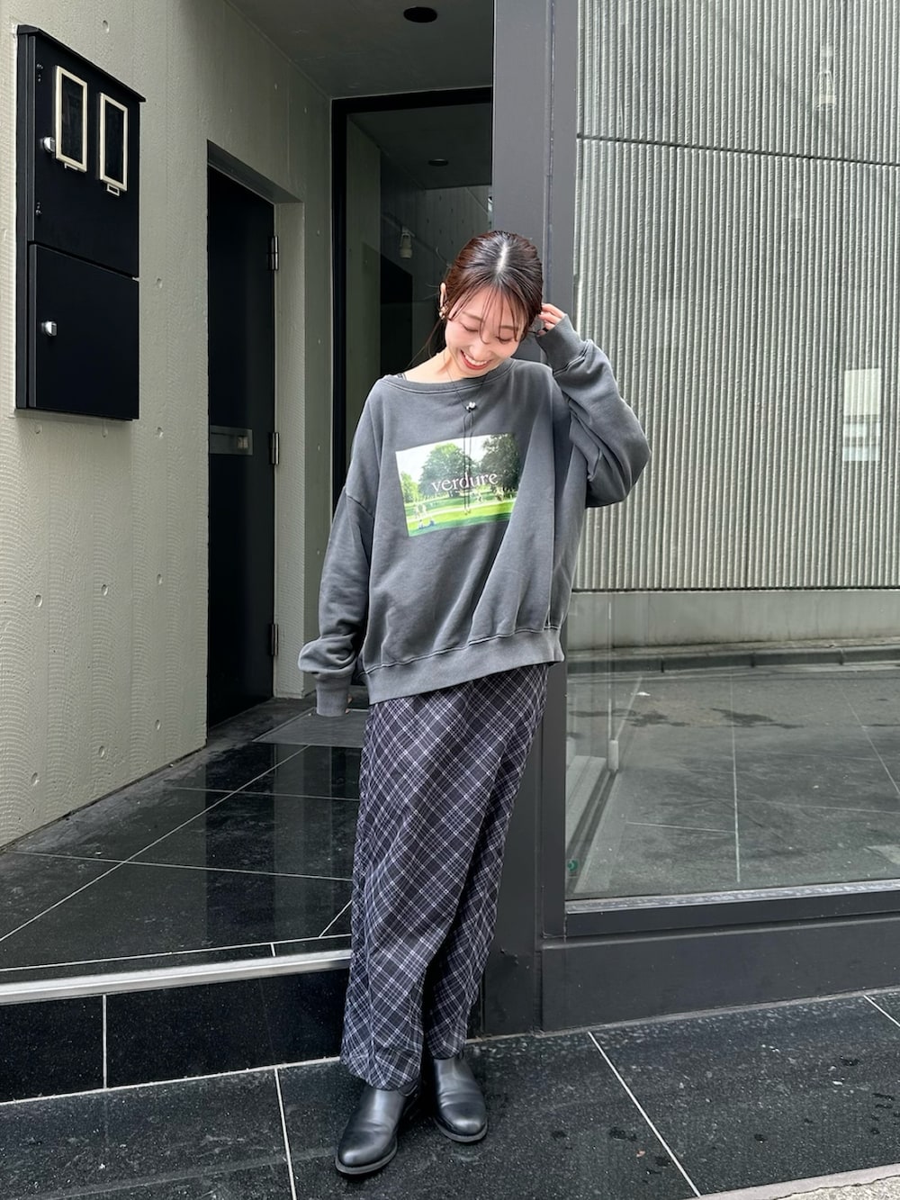 グレー系のスウェット、ブラック系のワンピース、ブラック系のブーツを着用したレディースの秋コーディネートの2枚目の写真