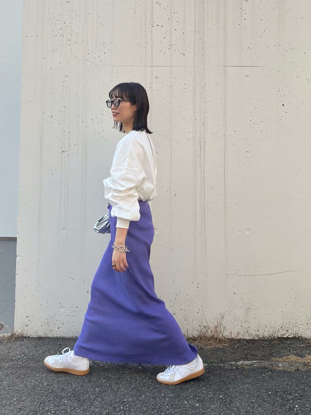 パープル系のスカート、ホワイト系のTシャツ/カットソーを着用したレディースの春コーディネートの3枚目の写真
