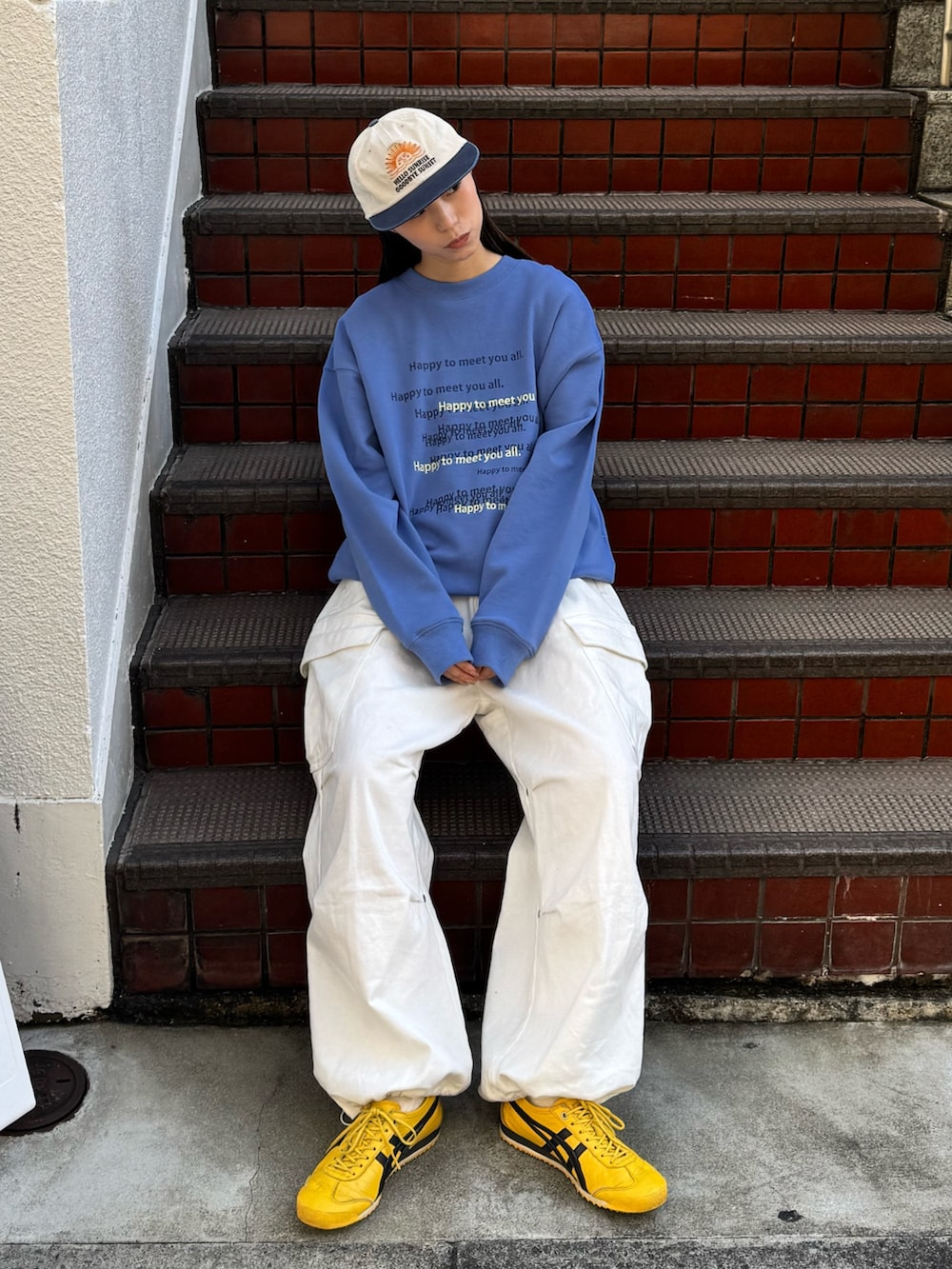 ブルー系のスウェット、ホワイト系のその他パンツ、イエロー系のシューズを着用したレディースの冬コーディネートの2枚目の写真