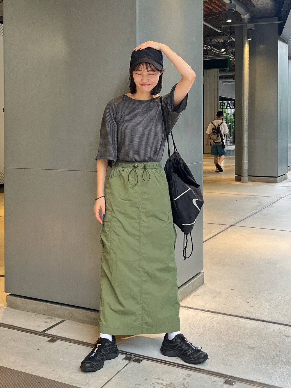 グレー系のTシャツ/カットソー、グリーン系のスカート、ブラック系のスニーカーを着用したレディースの夏コーディネートの2枚目の写真