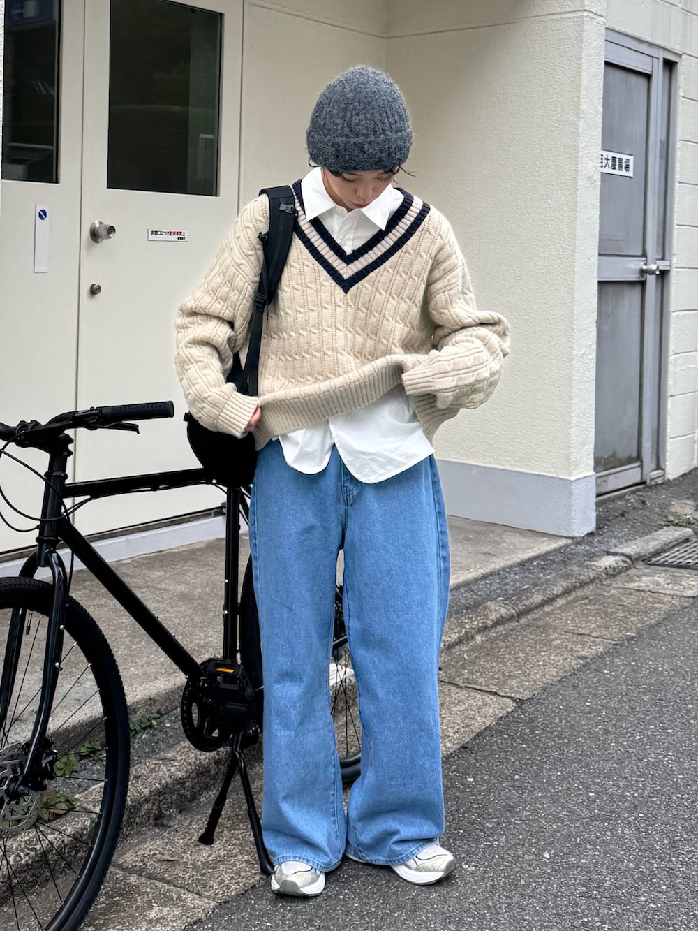 ベージュ系のニット/セーター、ホワイト系のシャツ/ブラウス、ブルー系のデニムパンツを着用したレディースの秋コーディネートの3枚目の写真