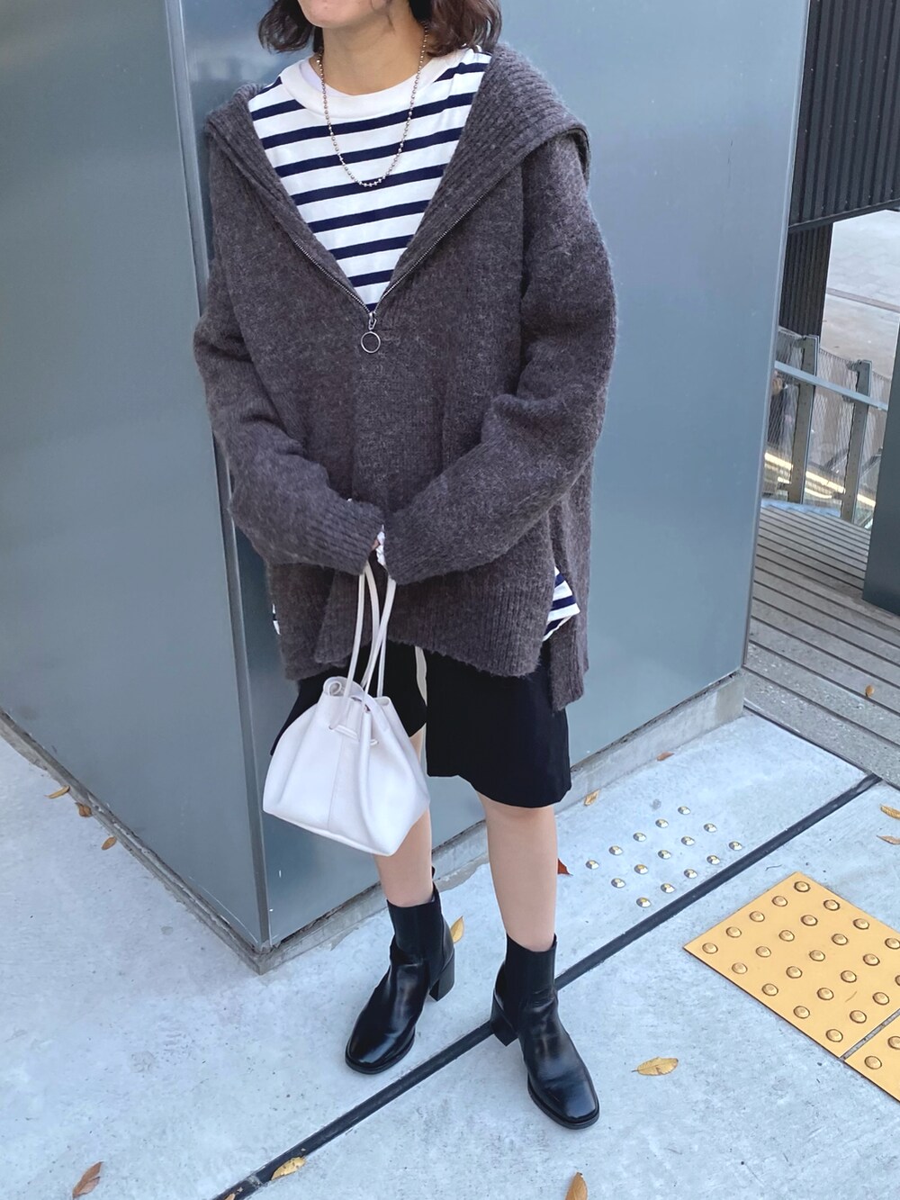 グレー系のニット/セーター、ブルー系のTシャツ/カットソー、ブラック系のその他パンツを着用したレディースの秋コーディネートの2枚目の写真