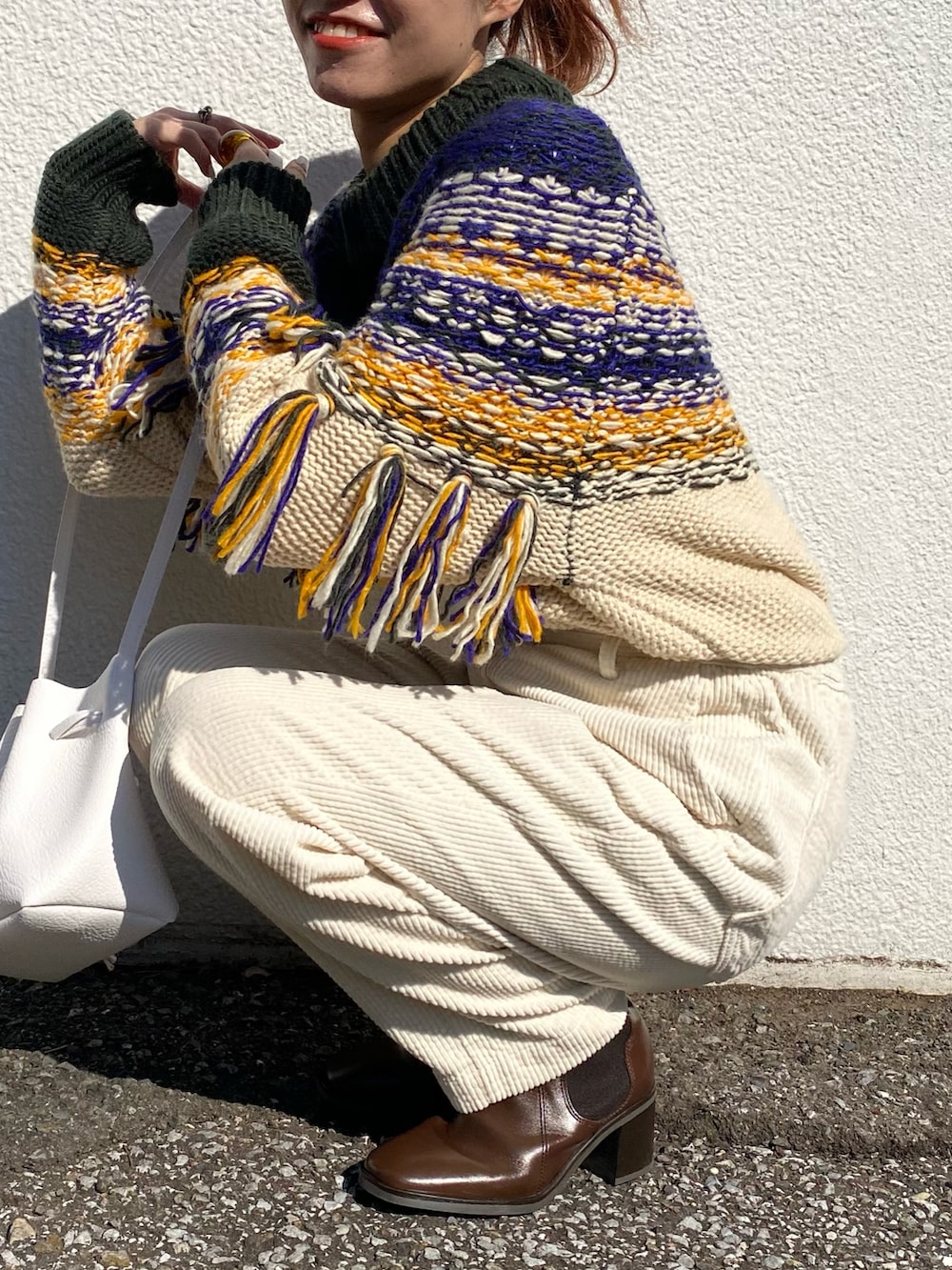 グリーン系のニット/セーター、ホワイト系のその他パンツ、ブラウン系のブーツを着用したレディースの冬コーディネートの2枚目の写真